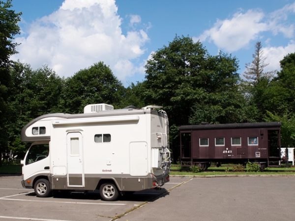 北海道で貨車と写るデイブレイク号マックレー製キャンピングカー